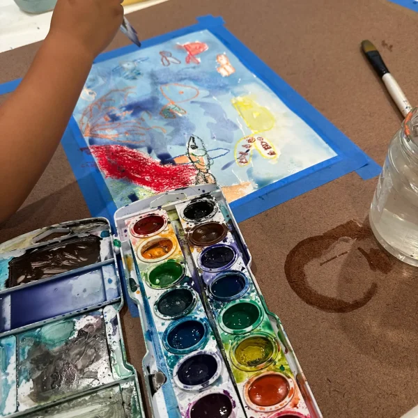 Child painting with watercolors and brush