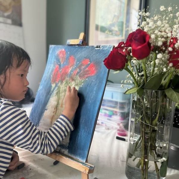 Home 16 Young child creating a flower painting with soft pastels during a kids art class at VIMA Gallery in San Diego