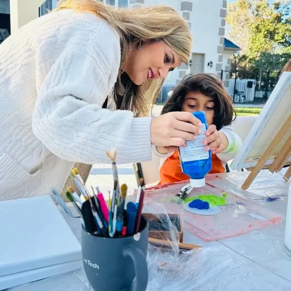 kids' art classes in san diego - Instructor guiding a young child with painting during Vima Gallery art class